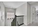 Upstairs hallway with dark wood railing and carpet at 27891 E 7Th Ave, Aurora, CO 80018