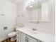 Bathroom featuring a vanity with storage and a large mirror with decorative lighting, with a toilet nearby at 16104 E Alaska Pl # D, Aurora, CO 80017