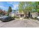 Exterior view of townhome with parking; features mature trees, blue and pink trim, and walkway at 16104 E Alaska Pl # D, Aurora, CO 80017