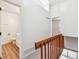 Hallway with wood railing, leading to a bathroom and bedroom with ample natural light and wood-look floors at 16104 E Alaska Pl # D, Aurora, CO 80017