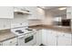 Bright kitchen featuring white appliances, laminate counters, and a view into an adjacent room at 16104 E Alaska Pl # D, Aurora, CO 80017