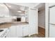Bright kitchen featuring white cabinets, ample counter space, and seamless access to the living area with a cozy fireplace at 16104 E Alaska Pl # D, Aurora, CO 80017