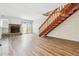Bright, empty living room featuring a fireplace, wood floors, and an eye-catching staircase at 16104 E Alaska Pl # D, Aurora, CO 80017