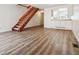Spacious living area with modern flooring, a wooden staircase, and a view into the adjacent kitchen at 16104 E Alaska Pl # D, Aurora, CO 80017