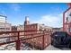 Cozy outdoor balcony featuring a black grill with a view of neighboring buildings and a clear blue sky above at 1435 Wazee St # 504, Denver, CO 80202