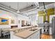 Open kitchen with breakfast bar and stainless steel appliances, and an industrial-style ceiling and pendant lighting at 1435 Wazee St # 504, Denver, CO 80202