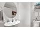 Bright powder room with stylish round mirror, wall mounted sink, and modern fixtures at 1435 Wazee St # 504, Denver, CO 80202