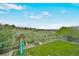 Spacious backyard featuring a green lawn, playset, and views of the surrounding landscape at 2140 S Coors Cir, Lakewood, CO 80228