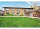 Large backyard with a well-maintained lawn, brick exterior, and access to the upper-level deck at 2140 S Coors Cir, Lakewood, CO 80228
