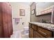 A bathroom featuring a brown wood vanity, a granite countertop, and tile flooring at 2140 S Coors Cir, Lakewood, CO 80228