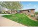 Charming brick home with a well-manicured lawn, mature trees, and an attached two car garage at 2140 S Coors Cir, Lakewood, CO 80228