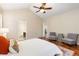 Comfortable bedroom featuring hardwood floors, ceiling fan, natural light, and access to the ensuite bathroom at 2112 Springs Pl, Longmont, CO 80504