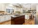 Spacious kitchen with island cooktop, granite countertops, custom cabinets, and hardwood floors at 2112 Springs Pl, Longmont, CO 80504