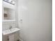 Simple half bath featuring a pedestal sink, white subway tile backsplash, and a decorative framed mirror at 1016 S Cook St, Denver, CO 80209