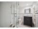 Bathroom with glass enclosed shower, marble vanity and black and white tile flooring at 1016 S Cook St, Denver, CO 80209