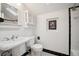 Quaint bathroom features a pedestal sink, toilet, and shower with black and white tile at 1016 S Cook St, Denver, CO 80209