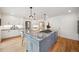 This kitchen features a gray island with granite countertops, stainless gas cooktop, hardwood floors, and white cabinets at 1016 S Cook St, Denver, CO 80209