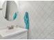 Bathroom featuring a white vanity, round mirror, patterned wallpaper, and a blue towel at 3792 S Pitkin Ct, Aurora, CO 80013