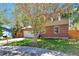 A two-story house with brick and vinyl siding surrounded by a well-manicured lawn and large trees at 3792 S Pitkin Ct, Aurora, CO 80013