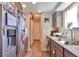Well-lit kitchen with wood flooring, granite countertops, stainless steel refrigerator, and gray cabinets at 3792 S Pitkin Ct, Aurora, CO 80013