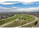 Beautiful aerial view of a community park with walking paths, surrounded by modern homes and the city skyline at 8768 E 54Th Pl, Denver, CO 80238
