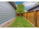 Green backyard with wood fence, offering a private and peaceful outdoor space at 8768 E 54Th Pl, Denver, CO 80238
