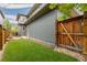 Green backyard with wood fence, offering a private and peaceful outdoor space and a wooden deck at 8768 E 54Th Pl, Denver, CO 80238