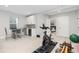 Finished basement with exercise equipment, a table, and a small beverage cooler at 8768 E 54Th Pl, Denver, CO 80238