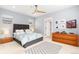 Comfortable bedroom with a ceiling fan, natural light, bedside tables, and patterned bedding at 8768 E 54Th Pl, Denver, CO 80238