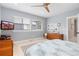 Bright bedroom with a ceiling fan, natural light, dresser, and patterned bedding at 8768 E 54Th Pl, Denver, CO 80238