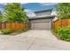 Home exterior with gray siding, a beige garage door, and neatly trimmed landscaping at 8768 E 54Th Pl, Denver, CO 80238