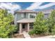 Two-story home with gray siding, manicured front yard landscaping, and a welcoming front porch at 8768 E 54Th Pl, Denver, CO 80238