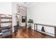 Hallway with wood floors, plant and coat rack, with a view of a bathroom and fireplace at 8768 E 54Th Pl, Denver, CO 80238