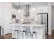 Modern kitchen with stainless steel appliances, white cabinets and island seating at 8768 E 54Th Pl, Denver, CO 80238