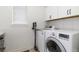 Laundry room with a washer, dryer, cabinets, and a small window at 8768 E 54Th Pl, Denver, CO 80238