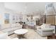 Open-concept living room with hardwood floors, stairs, kitchen, dining area, and neutral decor at 8768 E 54Th Pl, Denver, CO 80238