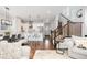 An open concept living room with a breakfast bar, dining area, hardwood floors, and a staircase at 8768 E 54Th Pl, Denver, CO 80238
