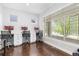 Bright home office featuring three desks, hardwood floors, and a large window with natural light at 8768 E 54Th Pl, Denver, CO 80238