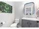 Cozy powder room with a vanity, mirror, toilet, artwork, and modern fixtures at 8768 E 54Th Pl, Denver, CO 80238