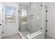 Modern glass-enclosed walk-in shower with gray tile and a built-in shelf at 8768 E 54Th Pl, Denver, CO 80238