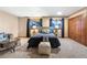 Cozy bedroom features natural light, comfortable bed, stylish decor, and hardwood closet doors at 9001 Eastridge Rd, Golden, CO 80403