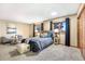 Relaxing bedroom featuring natural light, comfortable bed, stylish decor, and hardwood closet doors at 9001 Eastridge Rd, Golden, CO 80403