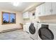 Bright laundry room equipped with a sink, cabinetry, washer, and dryer, plus a window view at 9001 Eastridge Rd, Golden, CO 80403