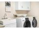 Functional laundry room equipped with a sink, cabinetry, washer, and dryer at 9001 Eastridge Rd, Golden, CO 80403