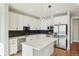 Stylish kitchen boasting white cabinets, stainless steel appliances, a large island, and sleek black countertops at 1559 N Hooker St, Denver, CO 80204