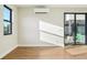 Bright living room featuring hardwood floors, a large window, and access to the outside through sliding glass doors at 1559 N Hooker St, Denver, CO 80204
