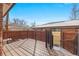 Wood deck with black railing and fenced perimeter showcasing winter scene at 536 Detroit St, Denver, CO 80206