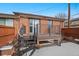 Back deck of brick home with a spiral staircase and snow in the yard at 536 Detroit St, Denver, CO 80206