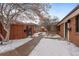 Inviting front yard with brick exterior, walkway, tasteful landscaping, and winter snow adding to the appeal at 536 Detroit St, Denver, CO 80206