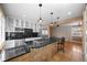 Eat-in kitchen has a stylish island with bar seating, stainless steel appliances, and lots of storage at 536 Detroit St, Denver, CO 80206